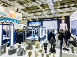 High-resolution realistic photograph of HP’s 3D printing systems and materials showcased at Formnext 2023, photographed in a real trade show environment, matching the look of existing press images about the same event. Avoid futuristic or stylized elements.