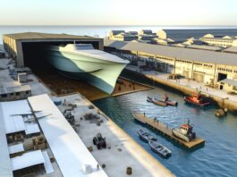 High-resolution realistic photograph of a large 3D-printed boat in a shipyard or dock, photographed in a real environment, matching the look of existing press images about the same project. Avoid futuristic or stylized elements.