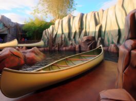 High-resolution realistic photograph of a 3D-printed polymer canoe used in Disney's Jungle Cruise ride, placed in a real theme park environment with natural lighting and background. Avoid futuristic or stylized elements.