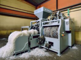 Turn Your Failed 3D Prints into New Filament with ExtrudeX High-resolution realistic photograph of ExtrudeX filament recycler in a workshop setting, showing shredded plastic being turned into filament. Avoid futuristic or stylized elements.