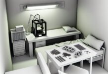 Connecticut Man Caught 3D Printing Illegal Gun Suppressors in Apartment High-resolution realistic photograph of a small apartment room with 3D printers on a desk and several plastic firearm suppressor parts laid out, photographed in a real environment, matching the look of existing press images about illegal 3D-printed weapons. Avoid futuristic or stylized elements.