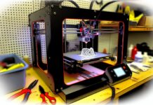 Colorado Lawmakers Pass Bill to Ban 3D Printing of Guns High-resolution realistic photograph of a 3D printer in action, with a focus on the printer's nozzle and a partially completed object, set in a workshop environment. Avoid futuristic or stylized elements.