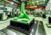 Transforming Wind Turbine Blade Mold Manufacturing with 3D Printing High-resolution realistic photograph of a 3D-printed wind turbine blade mold in a manufacturing setting, photographed in a real environment, matching the look of existing press images about the same. Avoid futuristic or stylized elements.